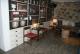 la industrial, decoración con microcemento gris y muebles blancos y pared de piedra 